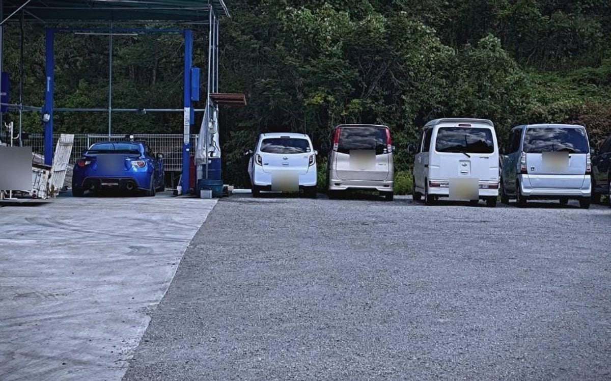 門型リフトのある作業場と、点検を待つお客様の車